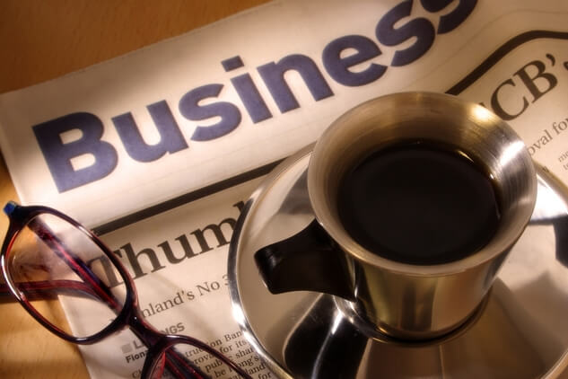 photo of a pair of glasses and a cup of coffee on a newspaper