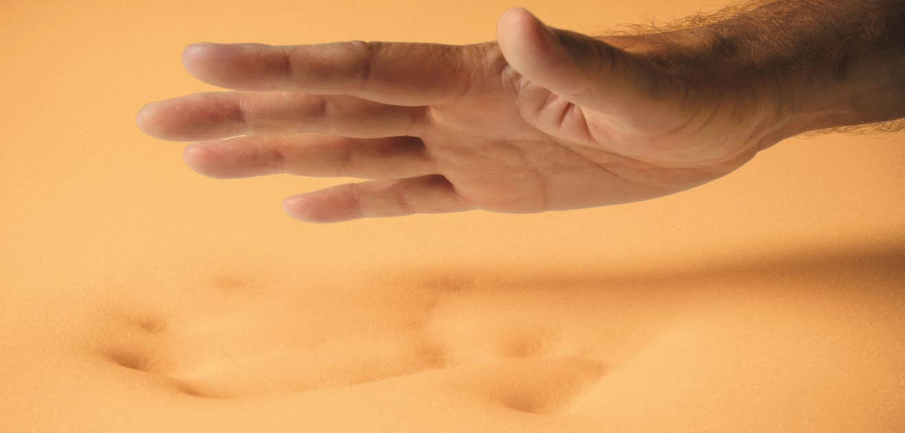 hand leaving a handprint in the sand