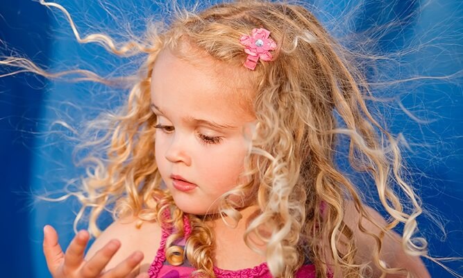 little blonde girl looking at hand