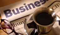 photo of a pair of glasses and a cup of coffee on a newspaper