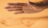 hand leaving a handprint in the sand